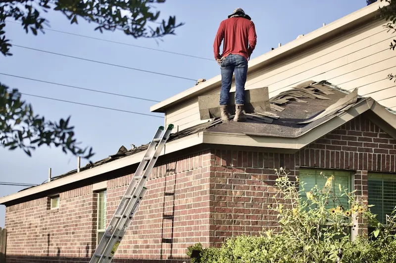 Professional roofer working on a residential roof in Green Manor Farm